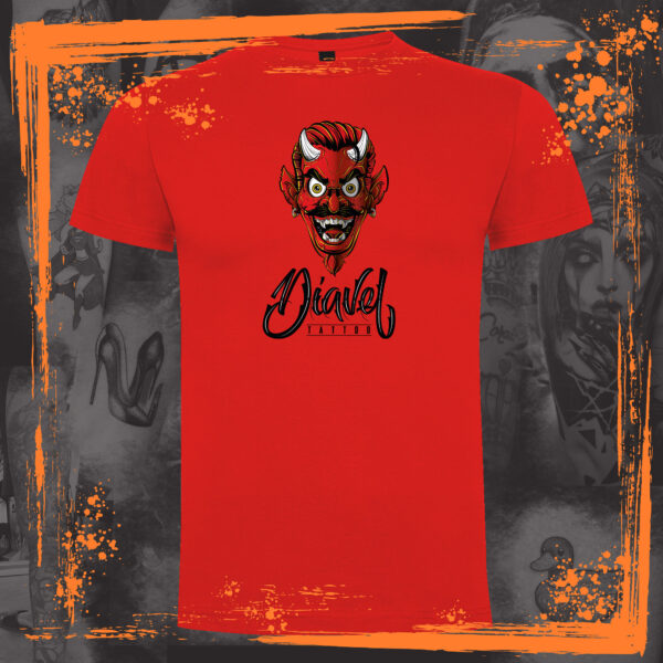 Camiseta de manga corta de color roja. Calidad cien por cien algodón. El diseño que tiene estampado en el pecho, representa el logotipo del estudio de tatuajes Diavel Tattoo, que es la cara de un demonio con bigote y cuernos sonriendo, con pendientes en las orejas y un peinado moderno. Bajo la cara del demonio, se lee "Diavel Tattoo". El fondo de la imagen donde se encuentra ubicada la camiseta está representado con varias fotos de los tatuajes realizados en este estudio con un cincuenta por ciento de opacidad , y los característicos restregones de pintura naranja de las publicaciones de Orange Moon.